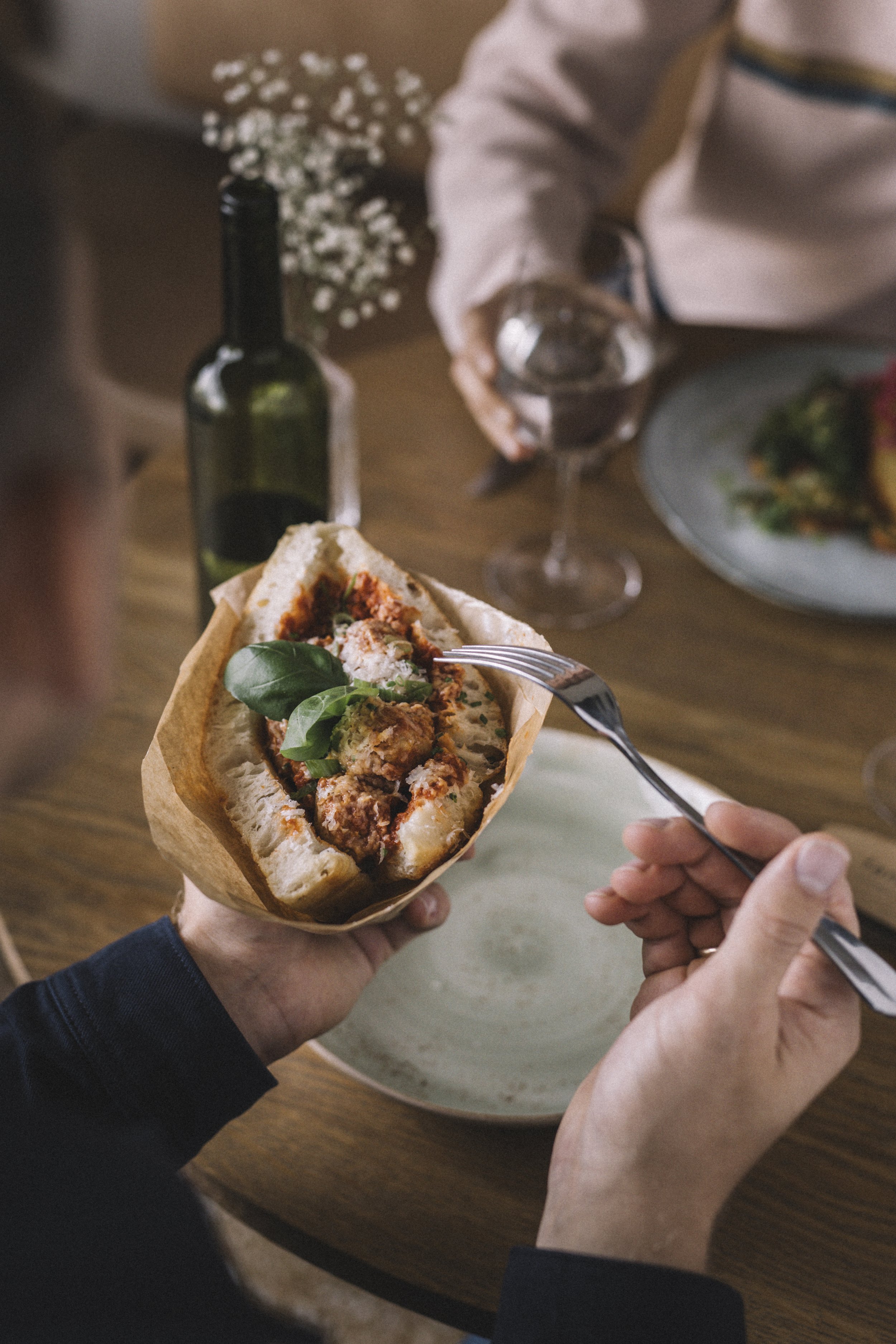 Fjellandskap med innsjø og grønne åser under en overskyet himmel.
