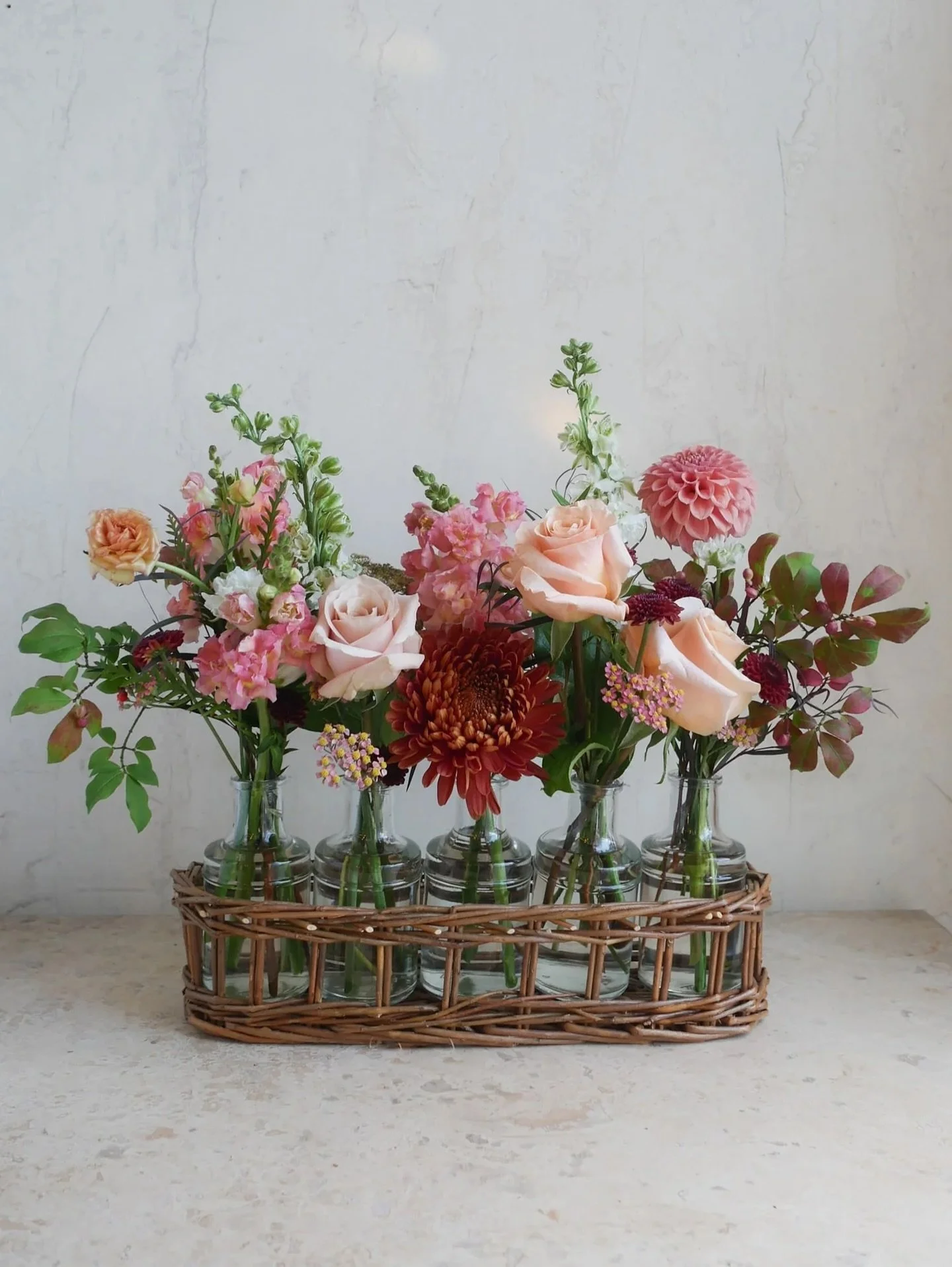 Autumn&rsquo;s beauty captured in blooms! This arrangement in our 5 vase wicker basket bottle carrier makes the perfect hostess gift this fall. And, it&rsquo;s a favorite among those learning floral design as the bottles can be refilled with garden c