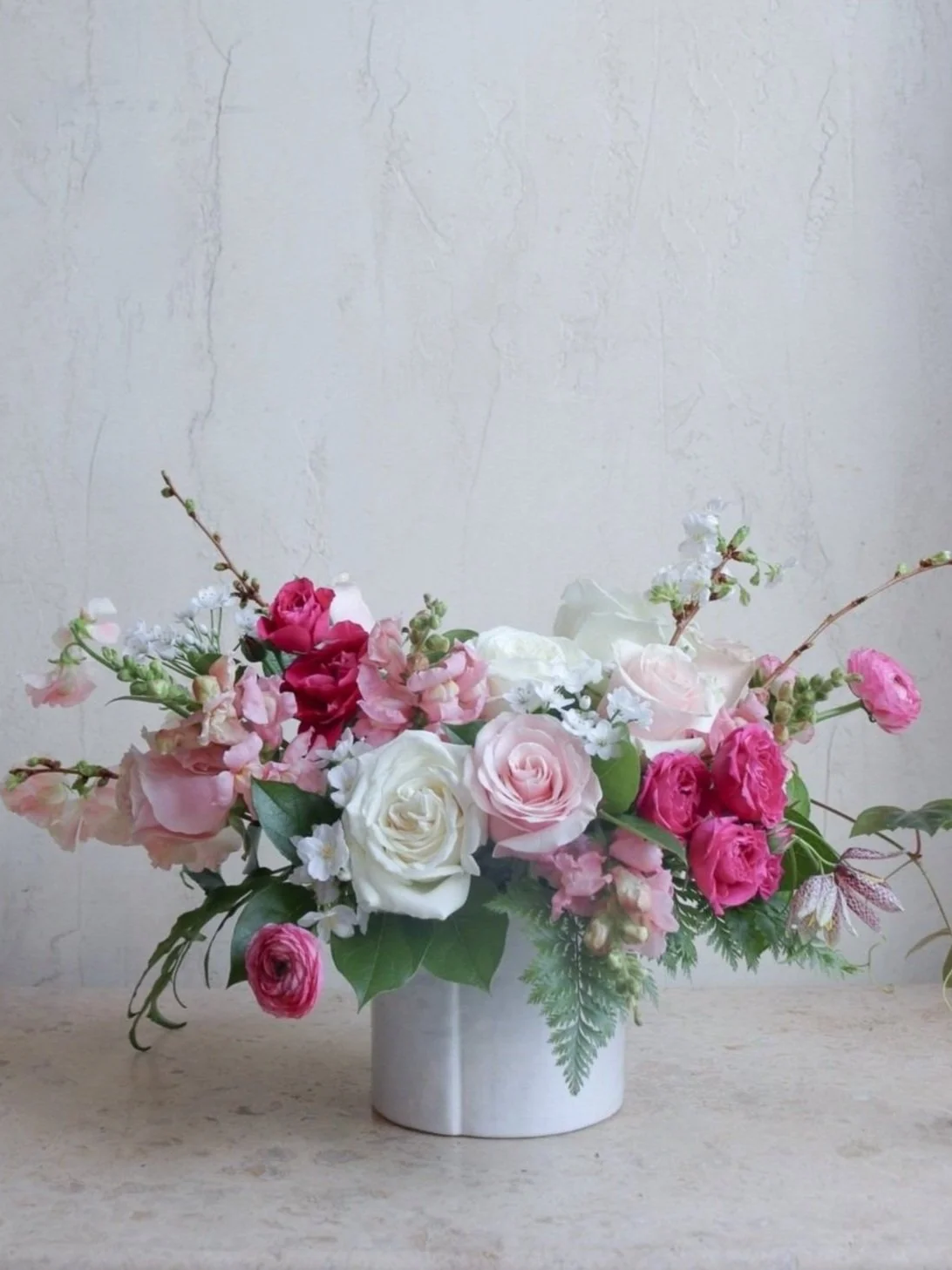 pink white magenta flower arrangement roses ranunculus snapdragon