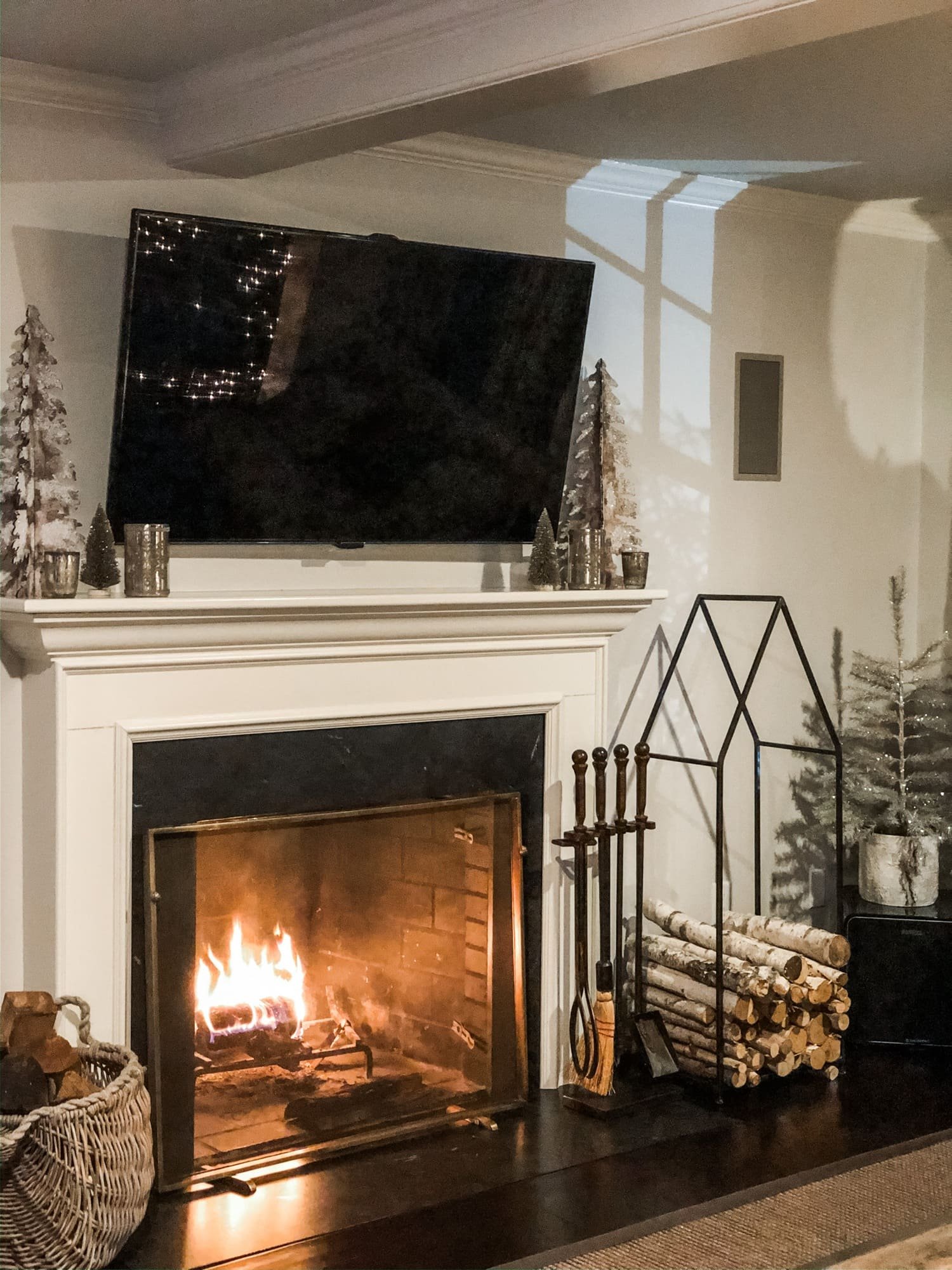 roaring fire in fireplace holiday decor on mantel firewood