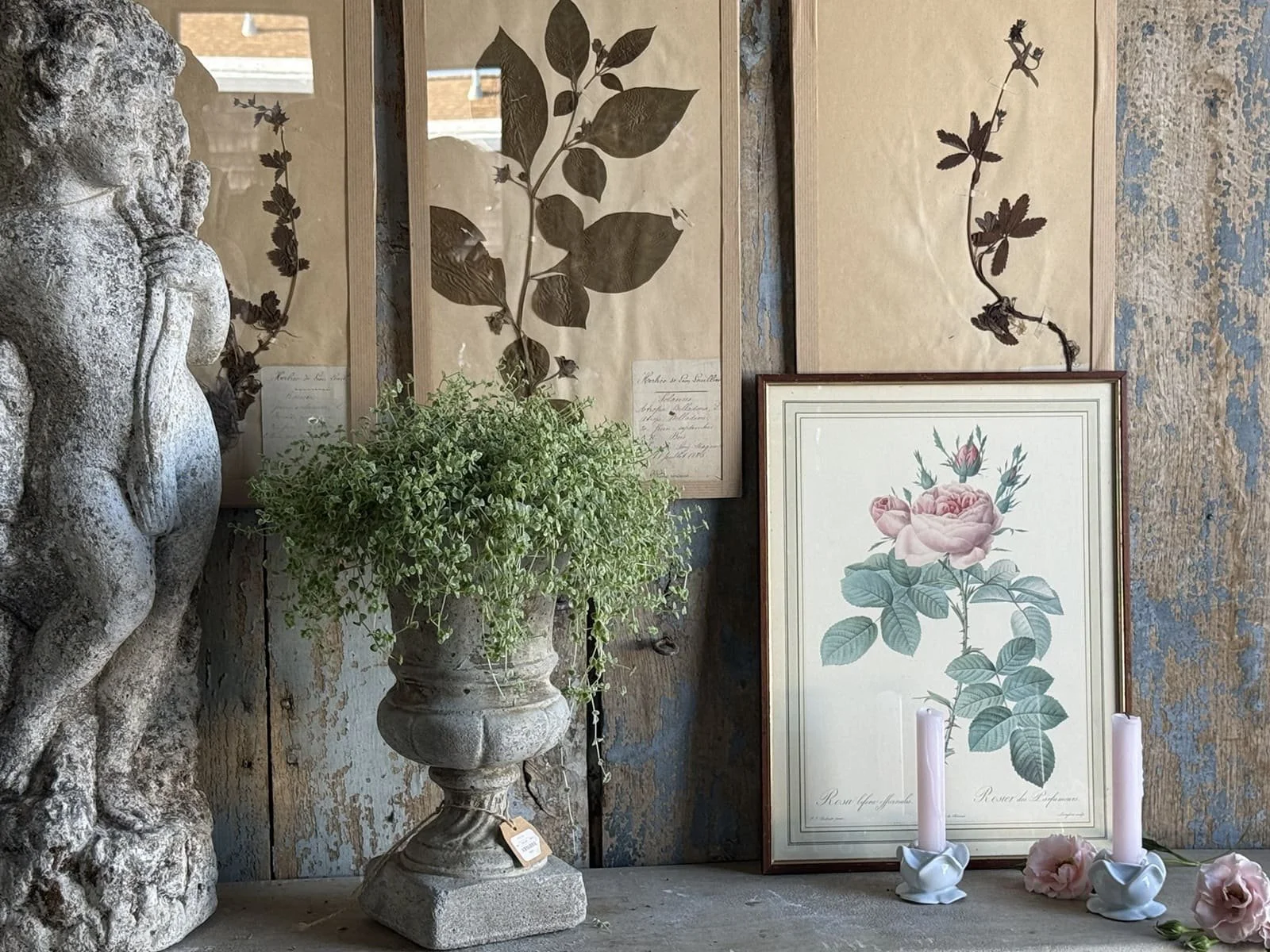 french antiques stone cherub statue urn planter engraved rose print pink taper candles porcelain rose candle holders