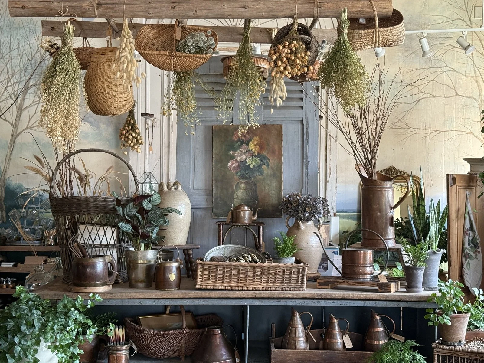 french antiques display hanging wicker baskets antique stoneware oiil jugs copper watering cans oil painting