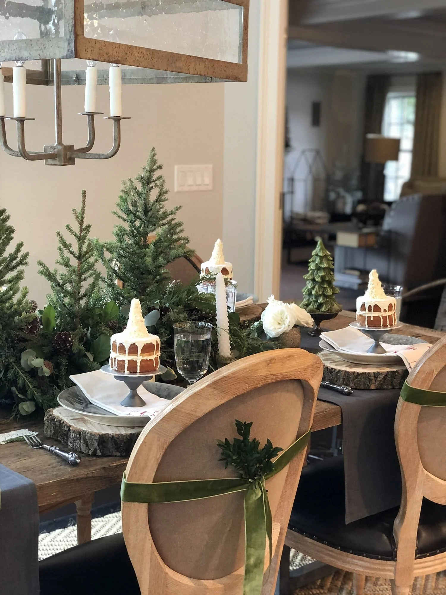 christmas dinner table evergreen trees flower centerpieces holiday cakes chairs with ribbon bows