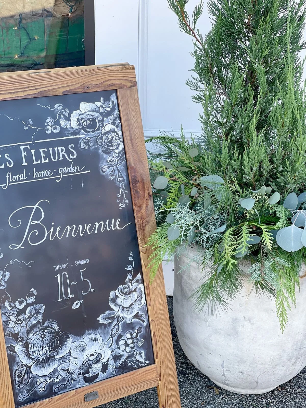 store hours chalkboard sign winter planter outdoor potted plant