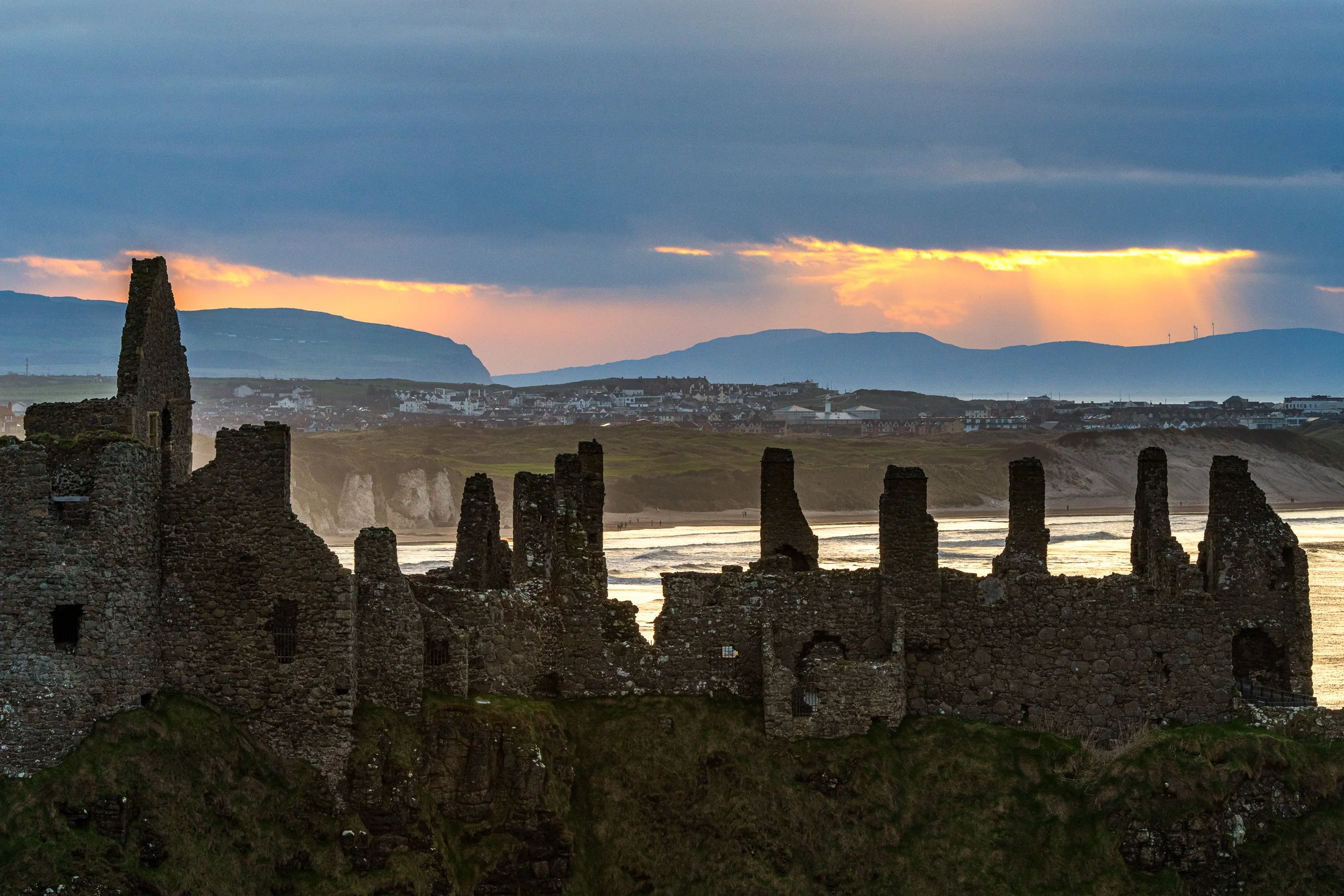 Dunluce Castle as the sun goes down over Inishowen, Donegal.