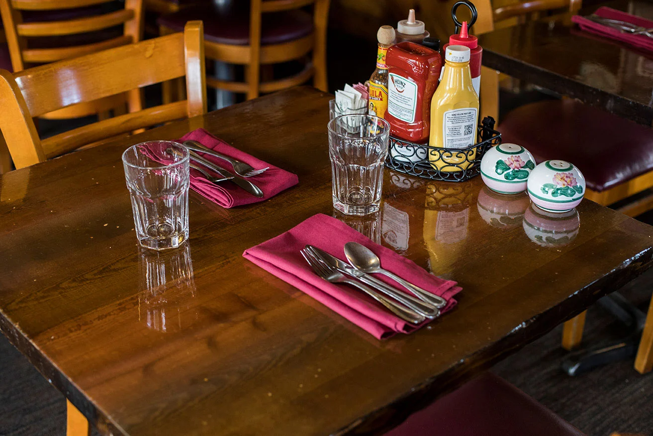 close-up-of-table-featuring-place-settings-and-condiments.jpg
