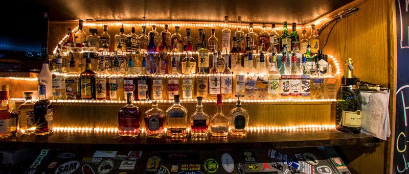 behind-the-bar-liquor-bottles-illuminated-by-backlight.jpg