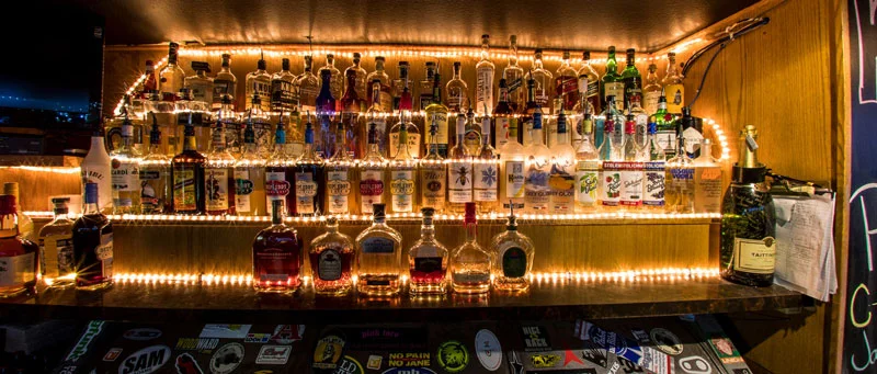behind-the-bar-liquor-bottles-illuminated-by-backlight.jpg