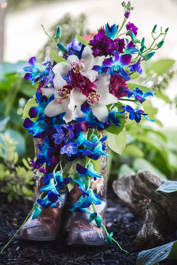 Bri Swarm chose stunning blue orchids to match with her palette as well as the color smoke bombs they used for photos. Eades-Swarm Wedding, page 66 of bridebook 2019. Image by Olivia Diane Photography.