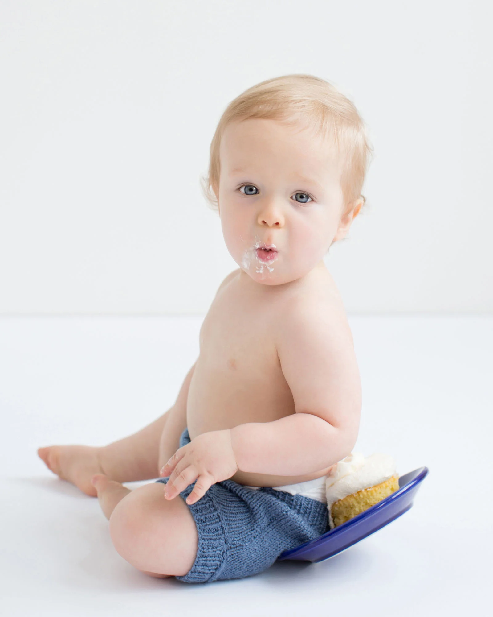 one_year_old_baby_boy_sitting_on_cupcake.jpg