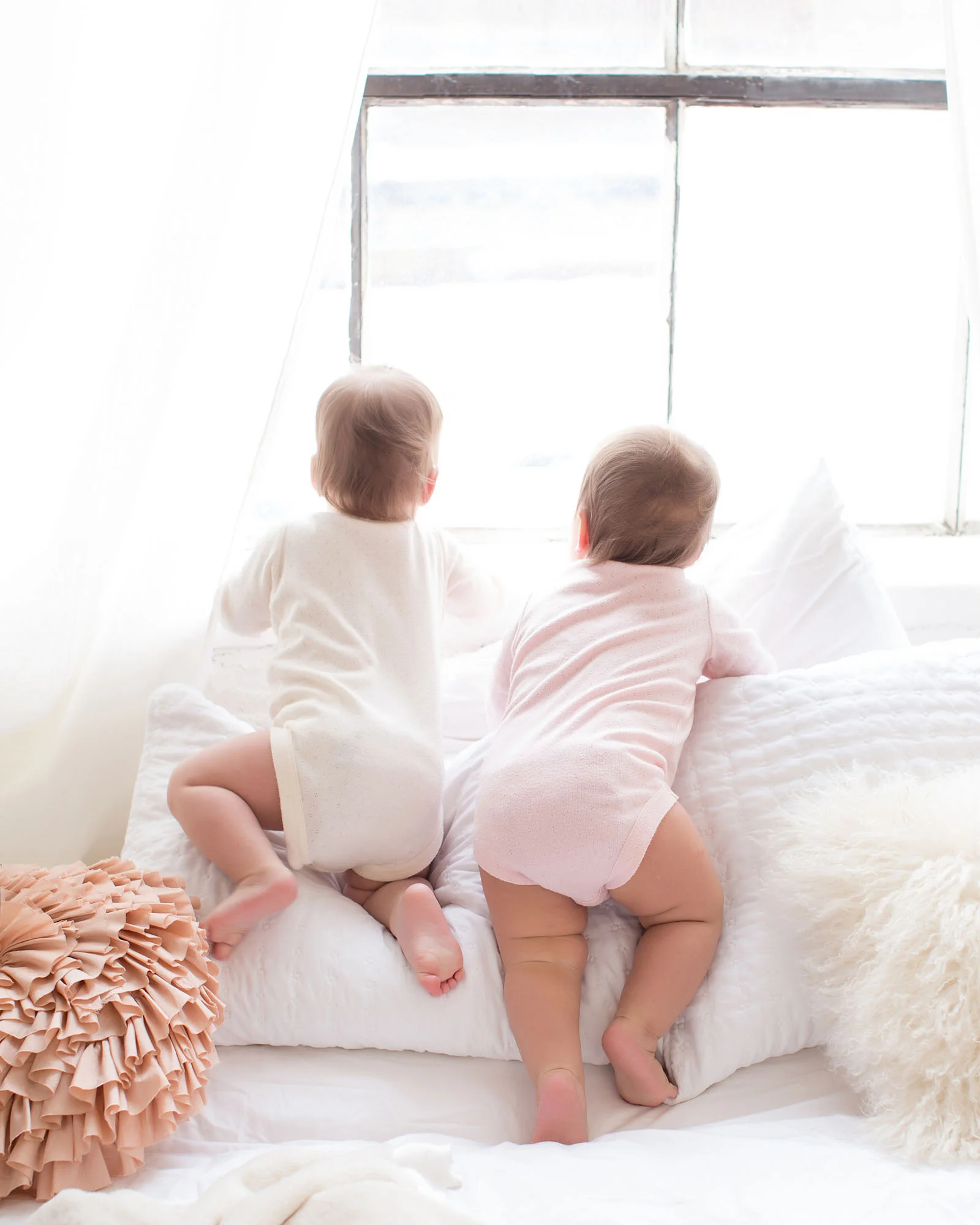 twin_girls_climbing_on_pillows.jpg