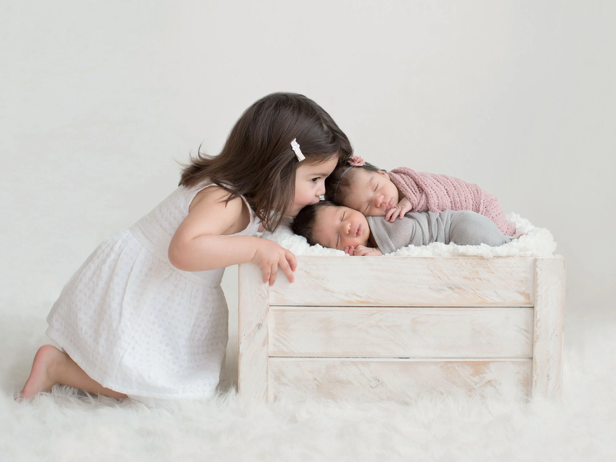 girl_kissing_newborn_twins.jpg