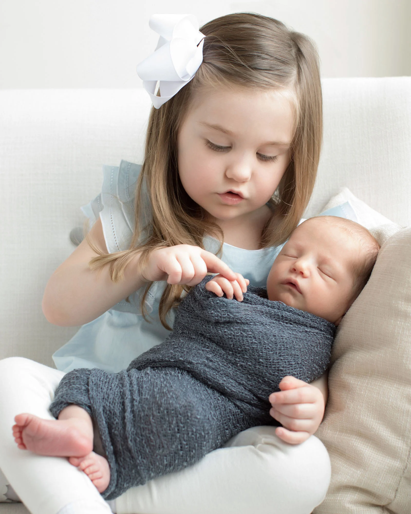 girl_counting_newborn_brother_fingers.jpg