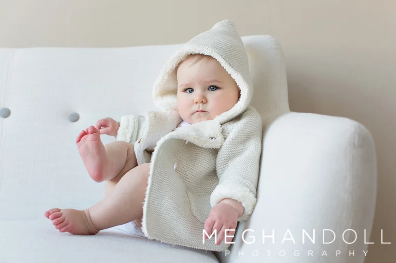 serious-little-six-month-old-boy-holds-his-toe