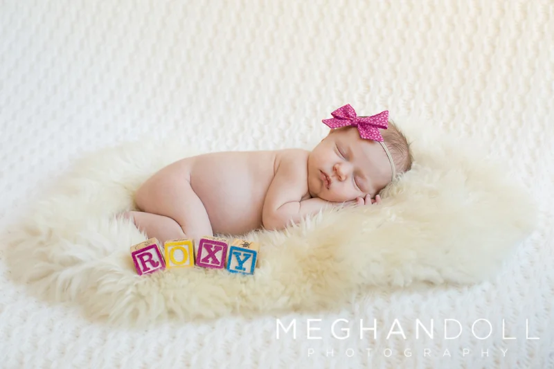 sleeping-newborn-girl-on-fur-with-blocks