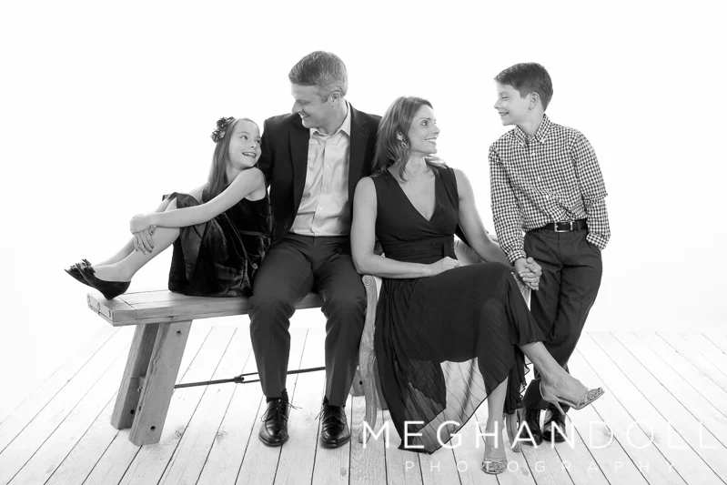 family-of-four-in-nice-clothes-smile-at-each-other
