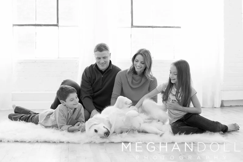 family-of-four-play-with-their-fuzzy-dog
