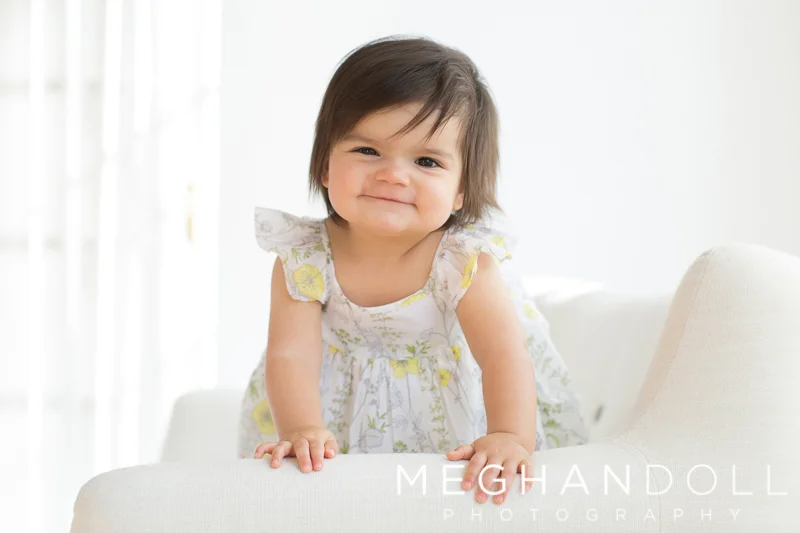 silly-one-year-old-girl-plays-peekaboo-on-couch
