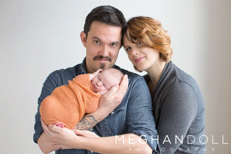 mom-and-dad-hold-newborn-son-in-orange
