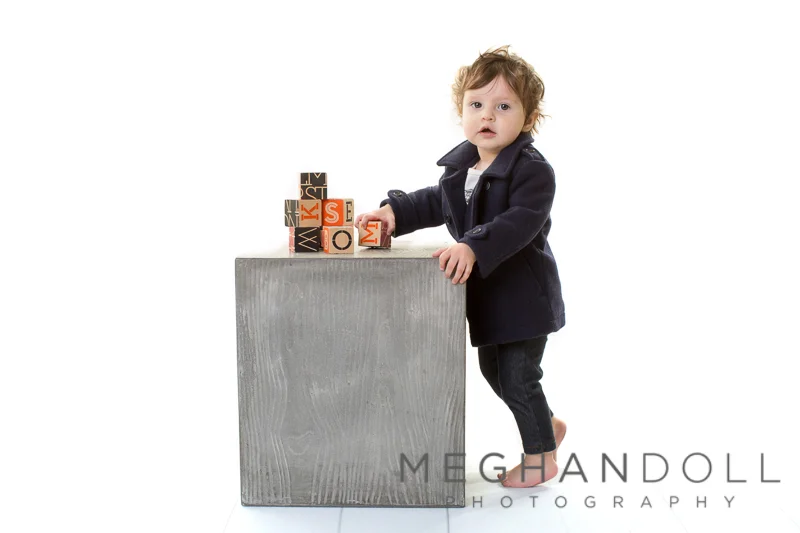 one-year-old-in-peacoat-plays-with-blocks