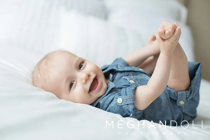 six-month-old-in-denim-plays-with-his-toes