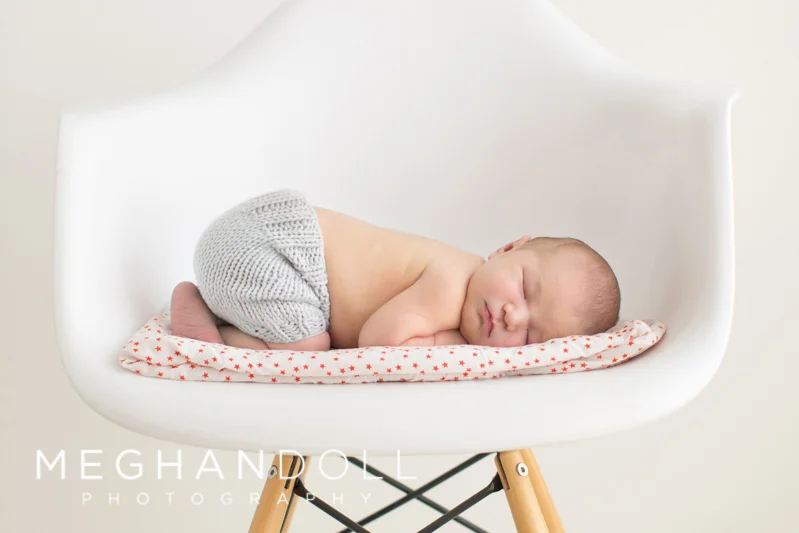 newborn-laying-in-whit-chair-sleeping