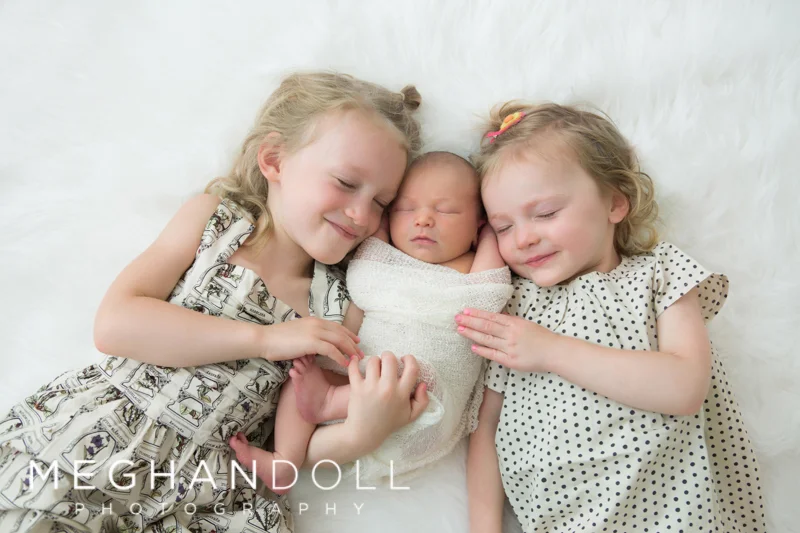 sisters-laying-next-to-their-brother-on-floor