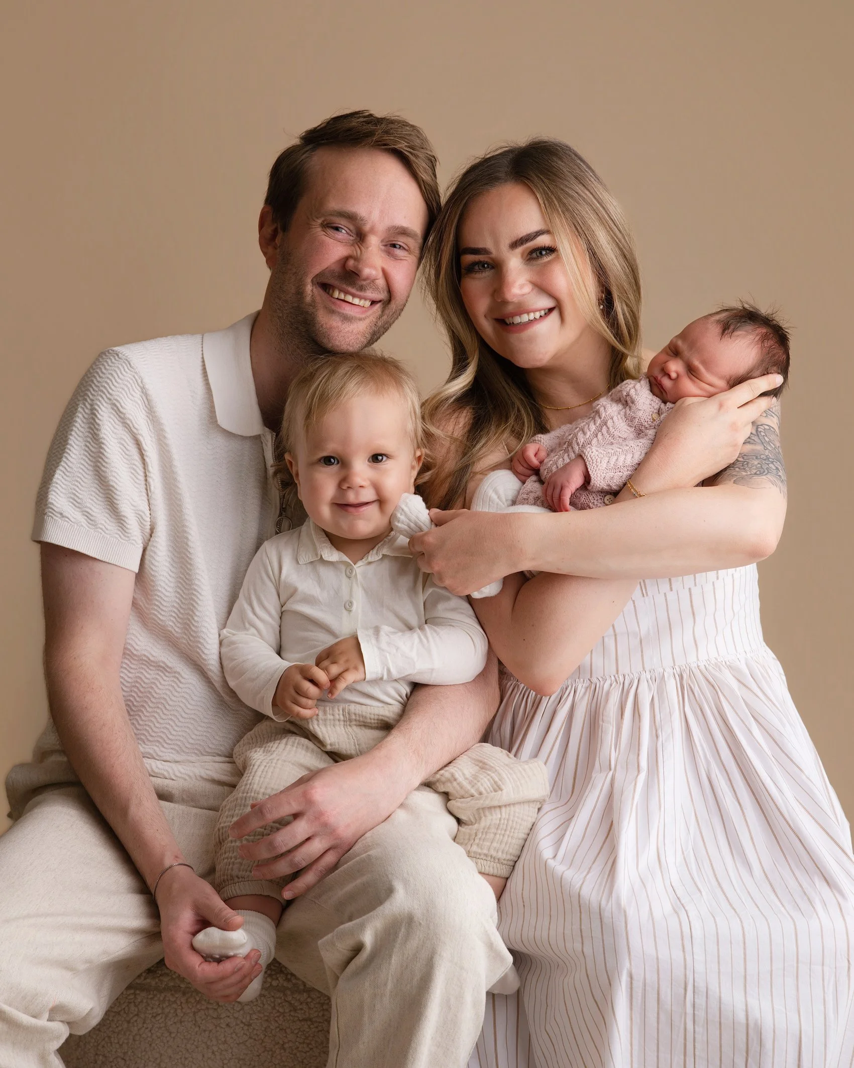 hele familien på nyfødtfotografering i studio beige bakgrunn. gi bort gavekort nyfødtfoto