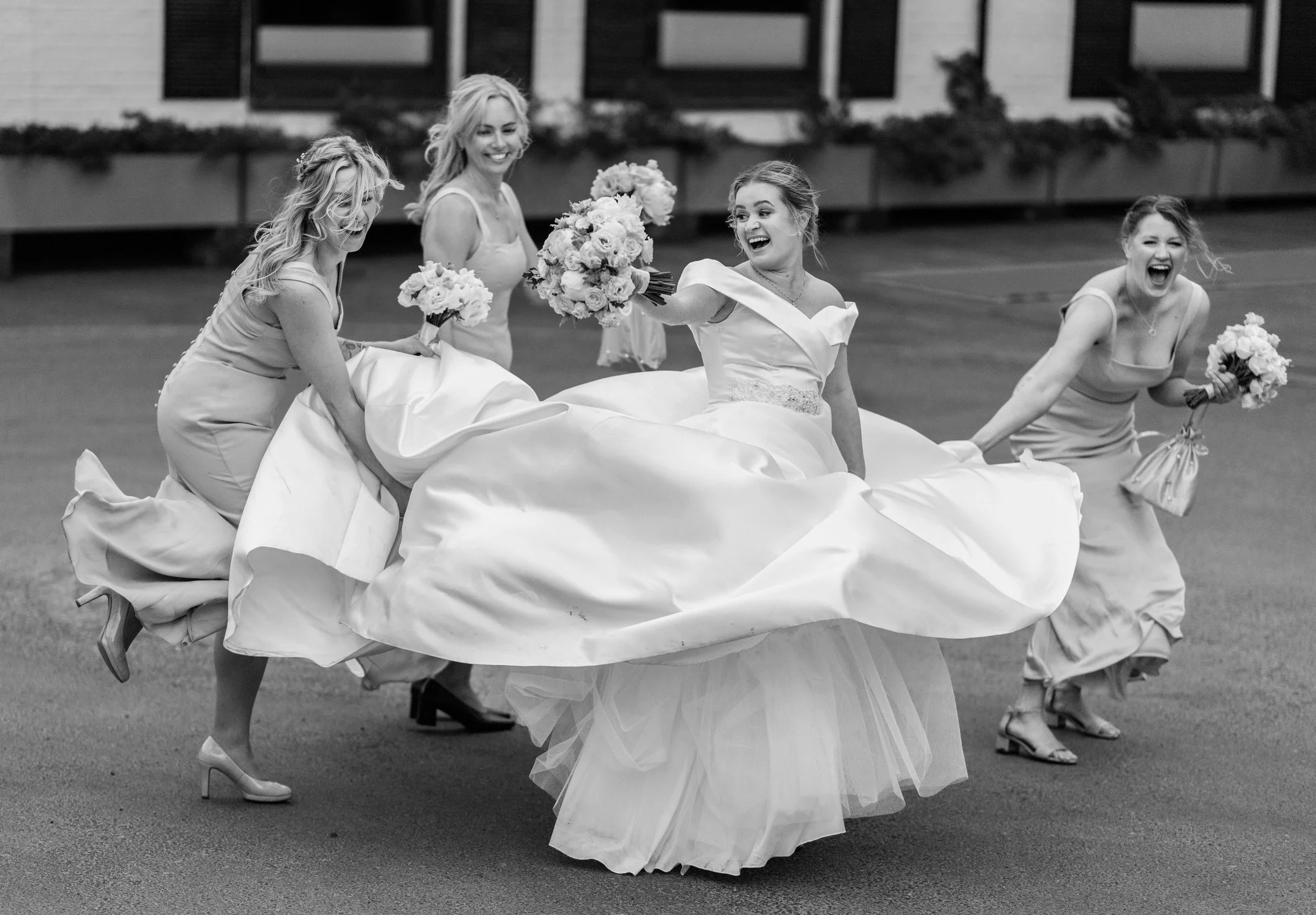 Bryllupsbilde i kategorien reportasje windy bride med forlovere og kjole som blåser i vinden på Fornebu.