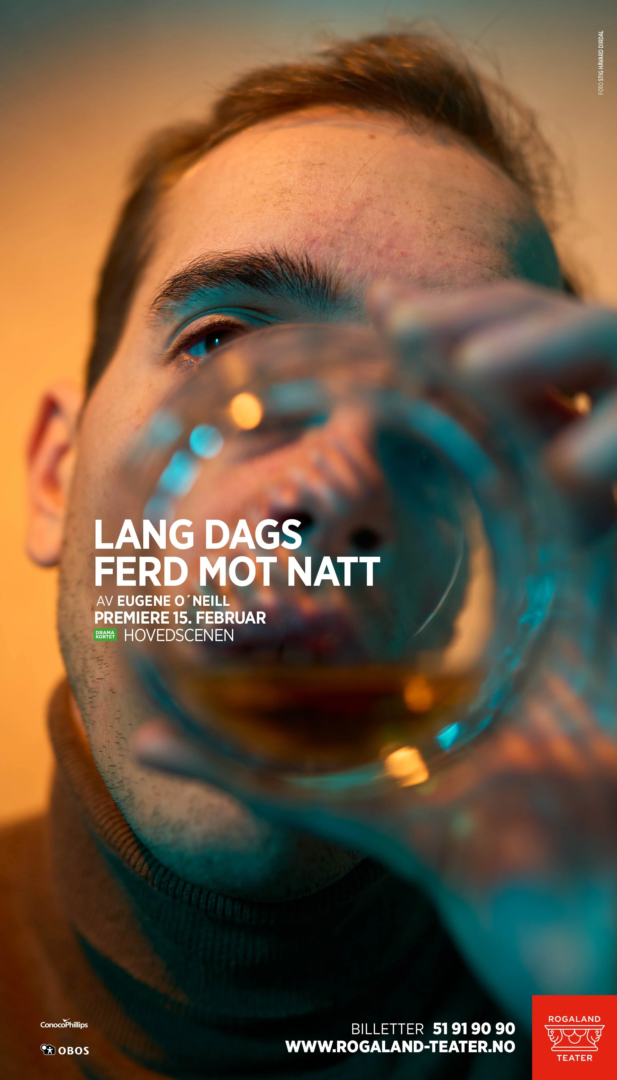 Key art for En lang dags ferd mot natt ved Rogaland Teater. Portrett fotografert gjennom bunnen av et whiskeyglass som en visuell metafor for alkoholens innvirkning. Konsept, foto og design av Stig Håvard Dirdal.