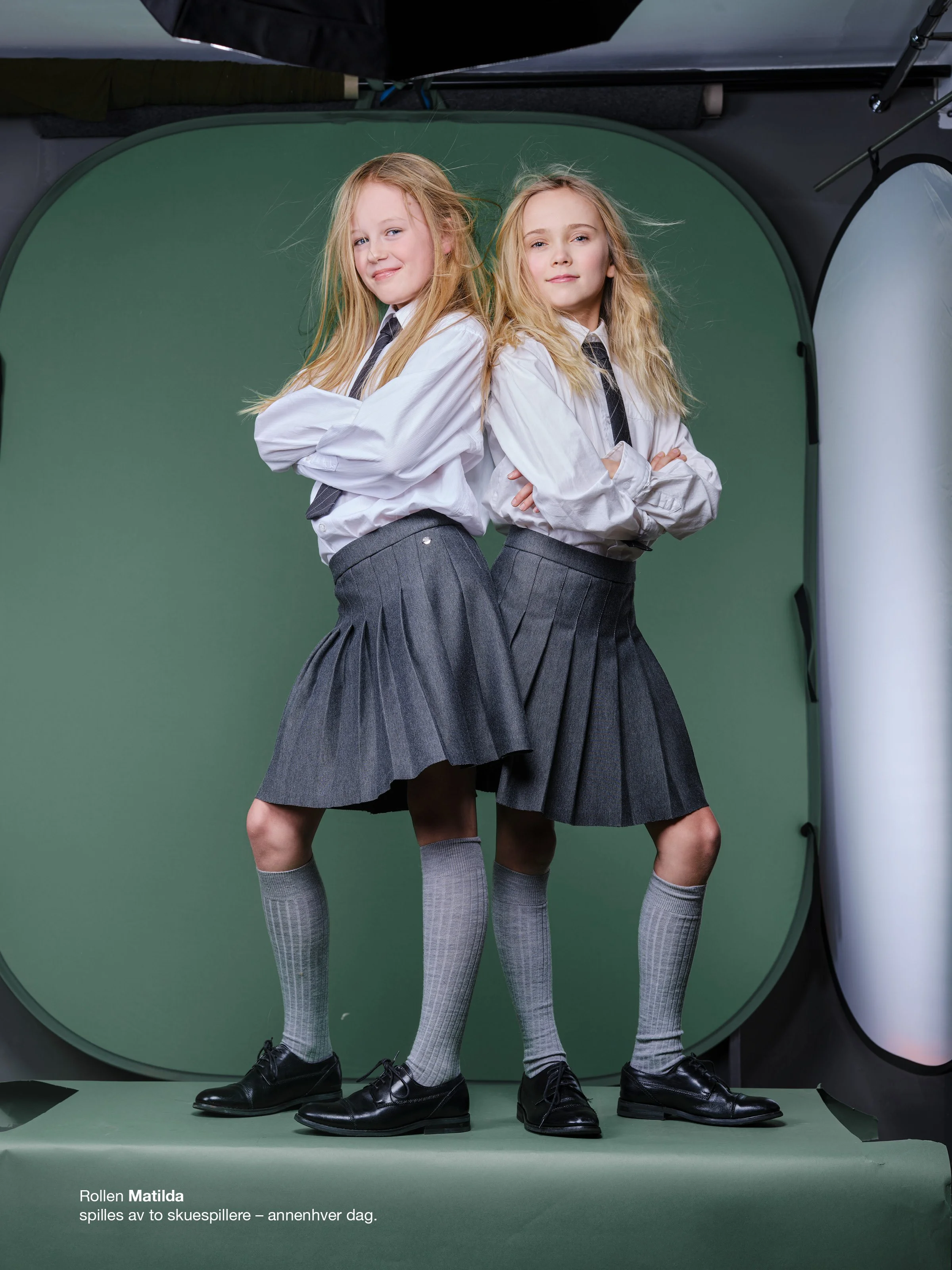 Produksjonsbilde fra fotograferingen av Matilda The Musical ved Rogaland Teater. De to skuespillerne som alternerte i rollen som Matilda poserer foran fotobakgrunn under produksjonen av kampanjematerialet. Fotografi av Stig Håvard Dirdal.