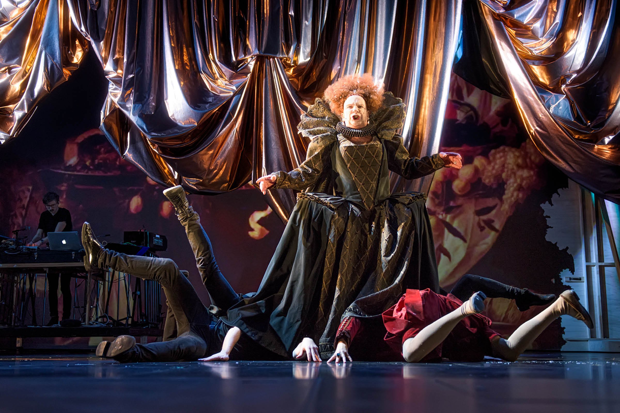 Teaterfotografi fra Rogaland Teaters oppsetning av Orlando. Bildet viser en sentral scene med overdådige kostymer, metalliske scenetepper og koreografert bevegelse. Fotografiet ble produsert som en del av det prisvinnende forestillingsprogrammet, der