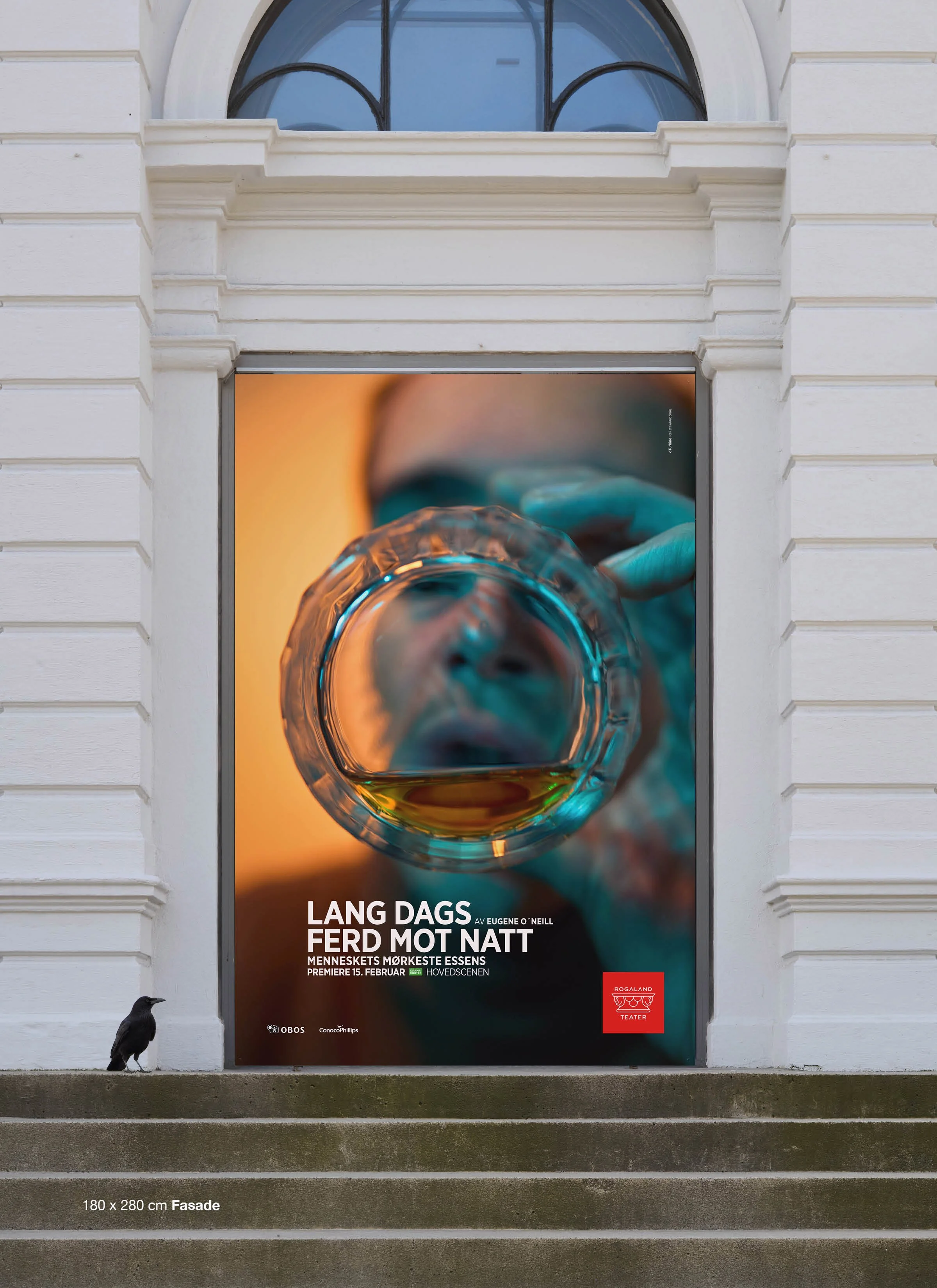 En lang dags ferd mot natt – Key Art på fasade
Det ferdige key art-konseptet slik publikum møtte forestillingen på Rogaland Teaters fasade. Ved å fotografere motivet gjennom bunnen av et whiskeyglass skapes et forvrengt perspektiv som understreker al