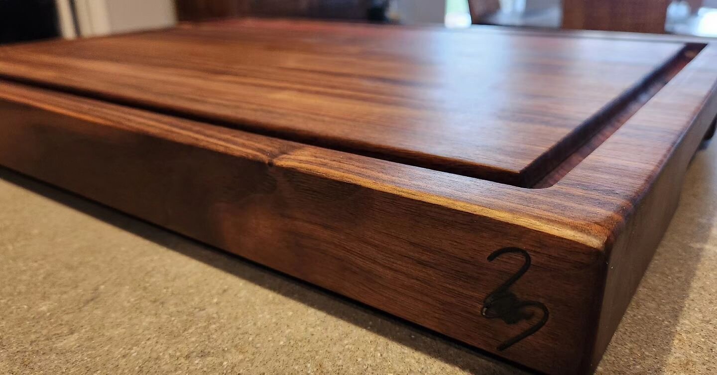 Finished this absolute beast of a board yesterday for Mark over at The Gym. A mixture of walnut and black walnut with some accent stipes of purpleheart create this giant 18&quot; x 24&quot; x 2&quot; cutting board complete with a &quot;Blood Gutter&q