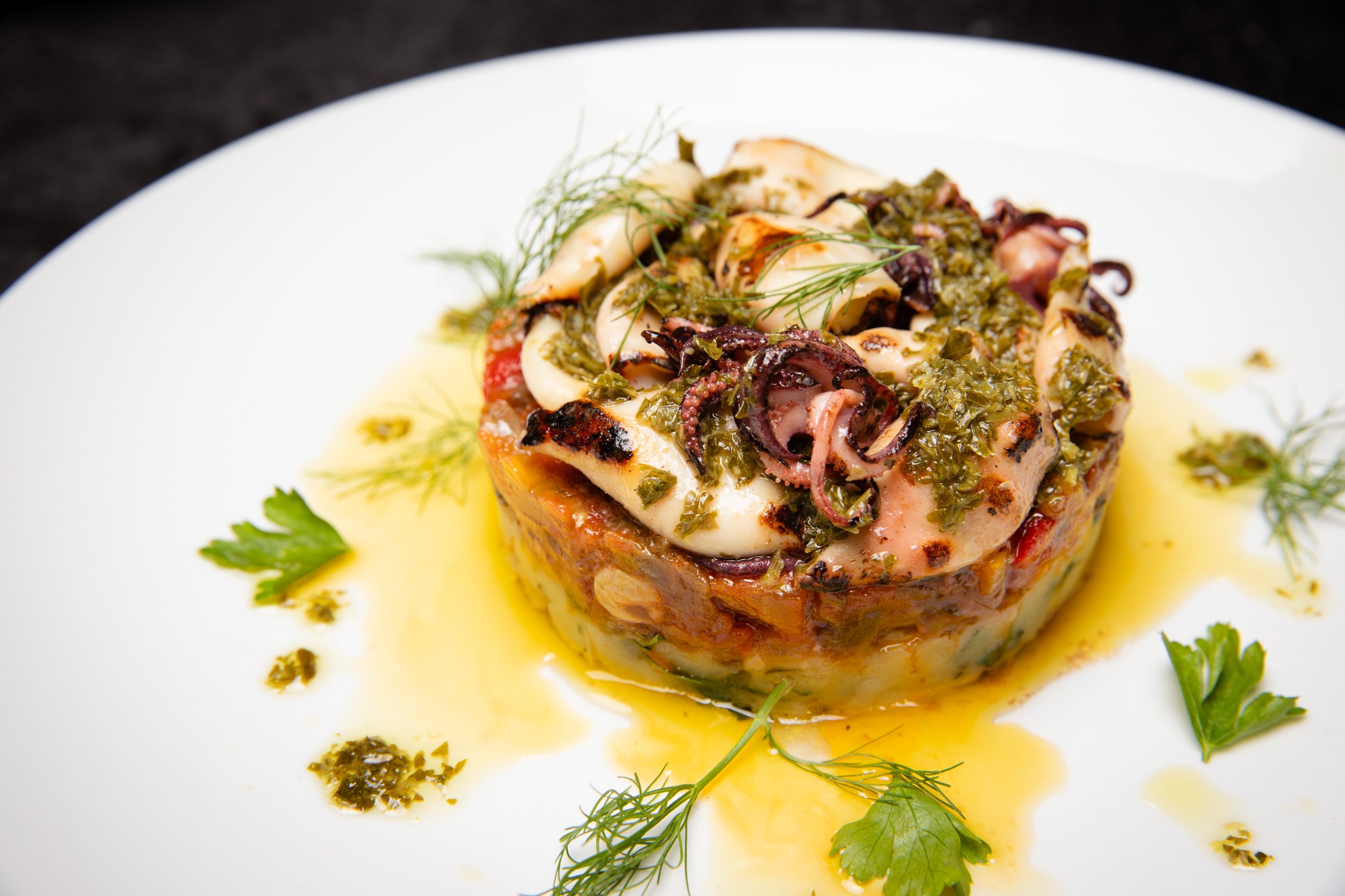 CALAMARI - grilled local fresh Monterey Bay squids, Yukon gold potato garlic & herbs, Caponata Messinese: eggplant, capers, bell pepper, raisins, sweet&sour tomato, Castelvetrano olives