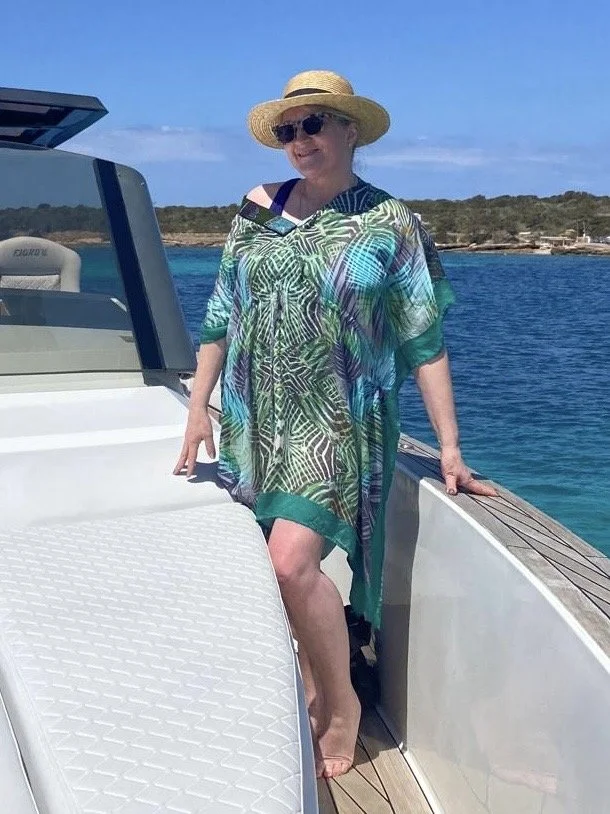 Marina Ask standing on a boat with the blue sea behind her