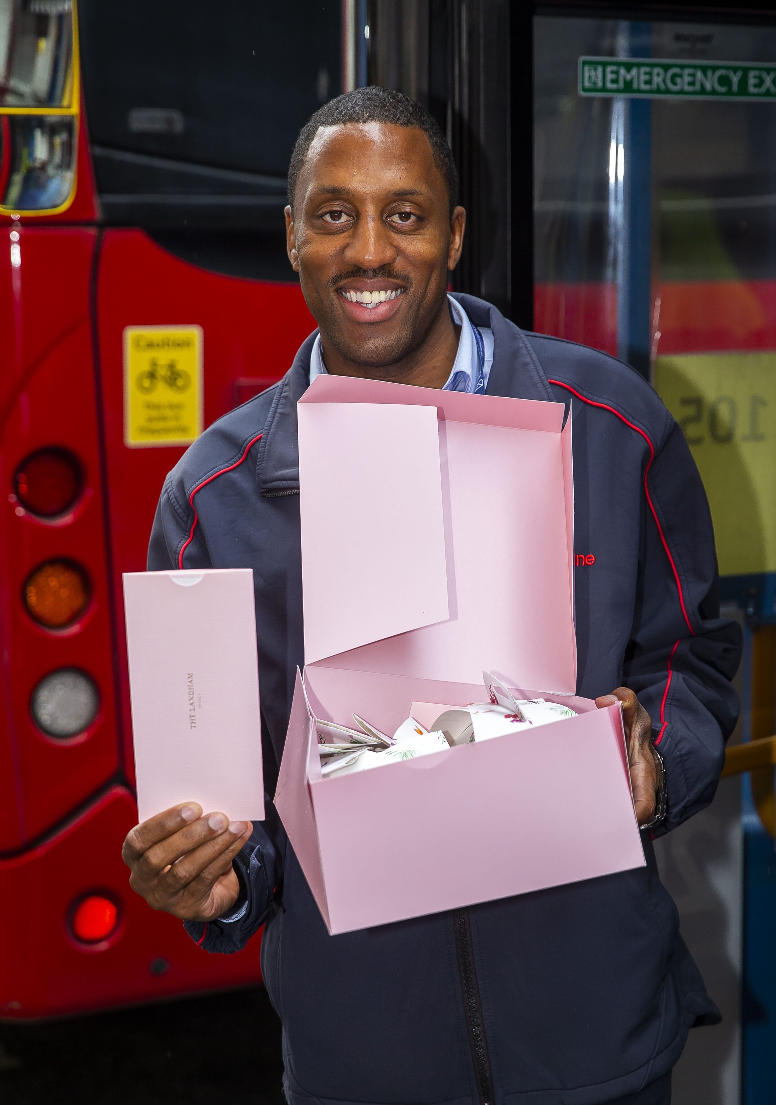 A bus driver holding the Langham afternoon box