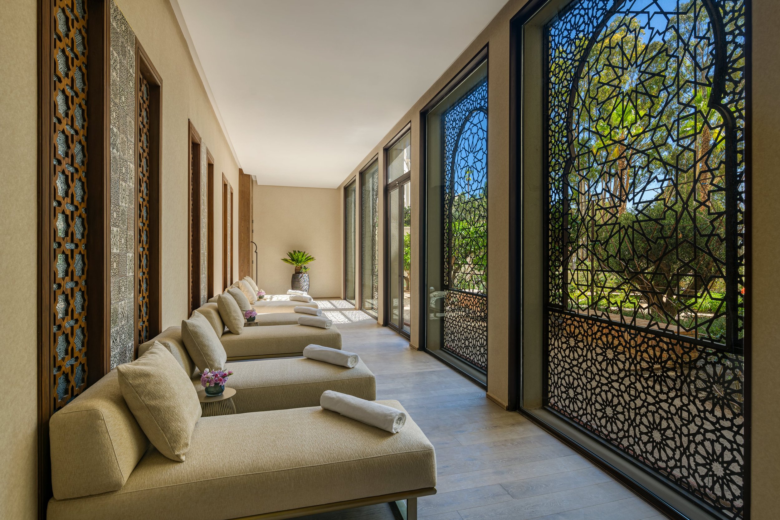 Loungers opposite a detailed black fence at the Fairmont Tazi Palace spa