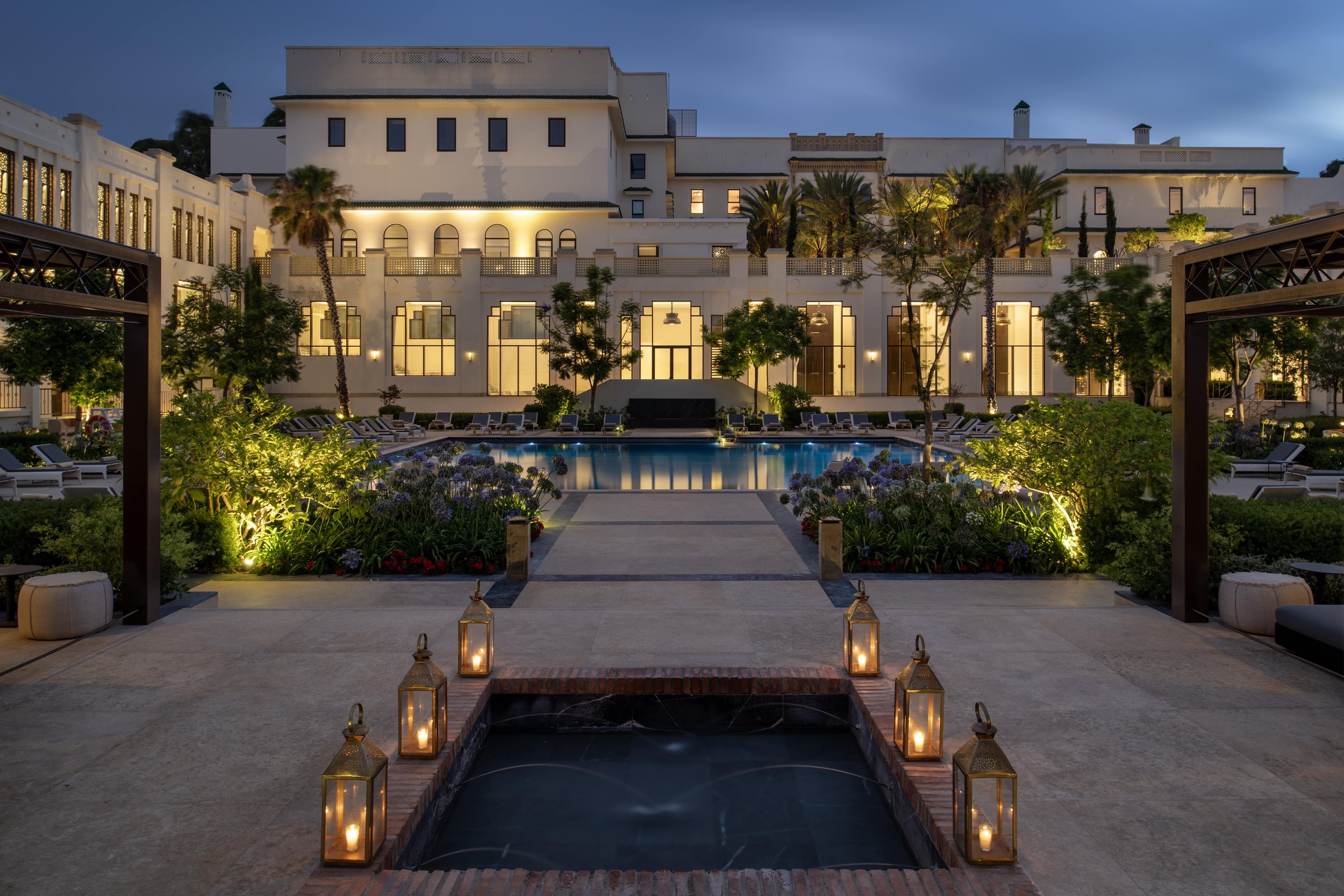 Exterior of Fairmont Tazi palace as the sun is setting and the garden lights are lit up