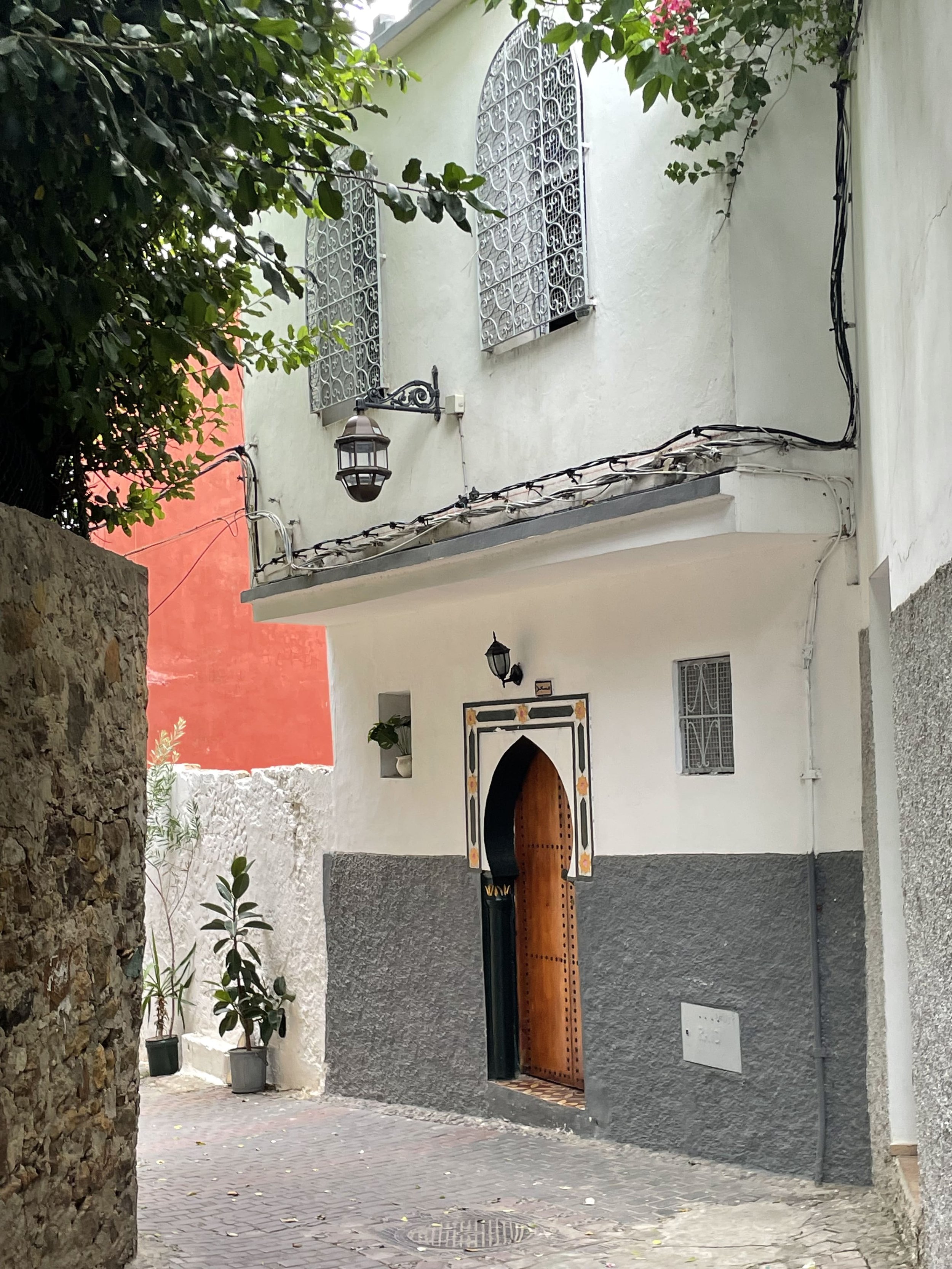 An white and grey building exterior down an alleyway