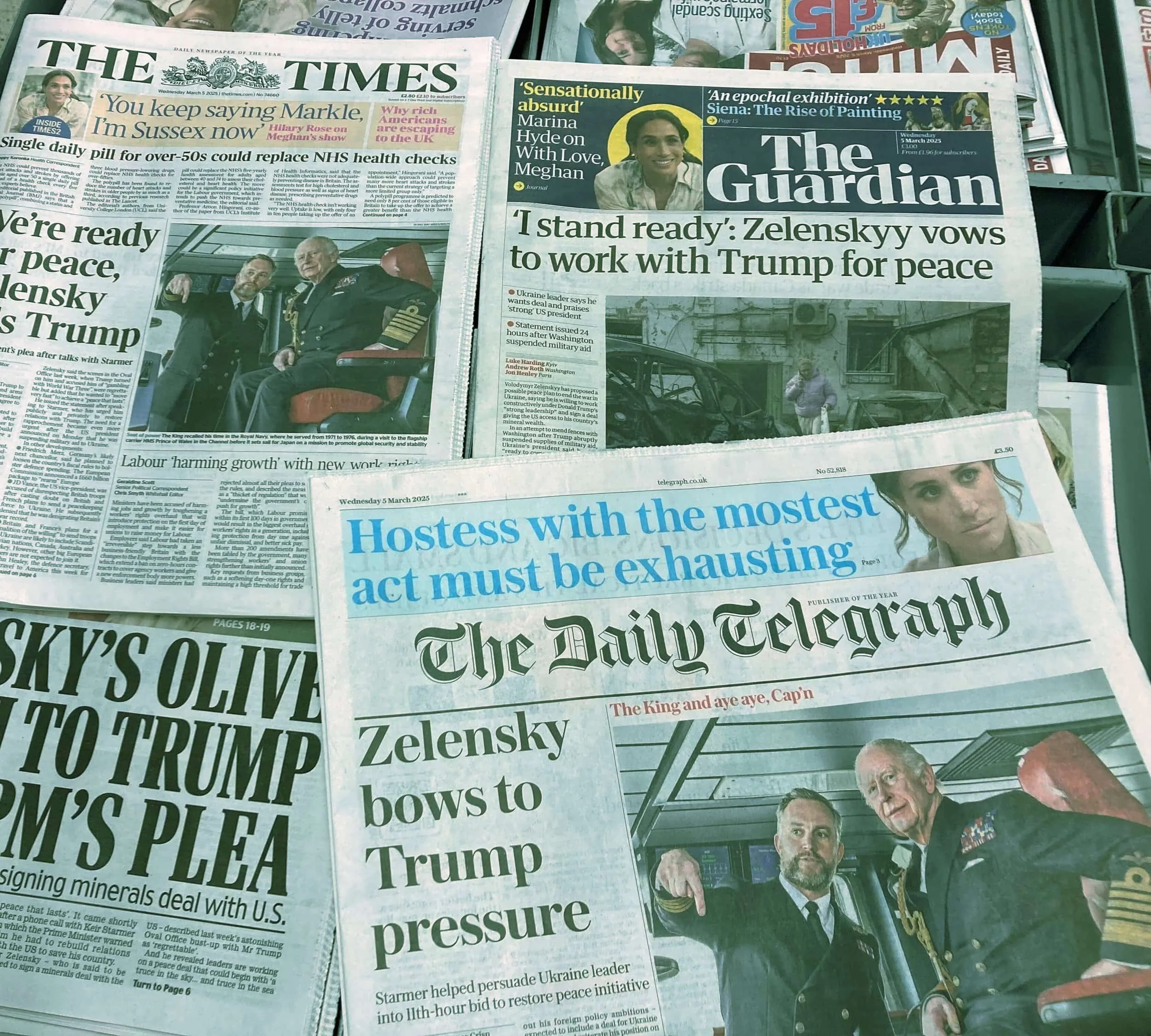 Several newspapers overlapping, with headlines about Zelenskyy and Trump, and a photo of Zelenskyy with military officials.