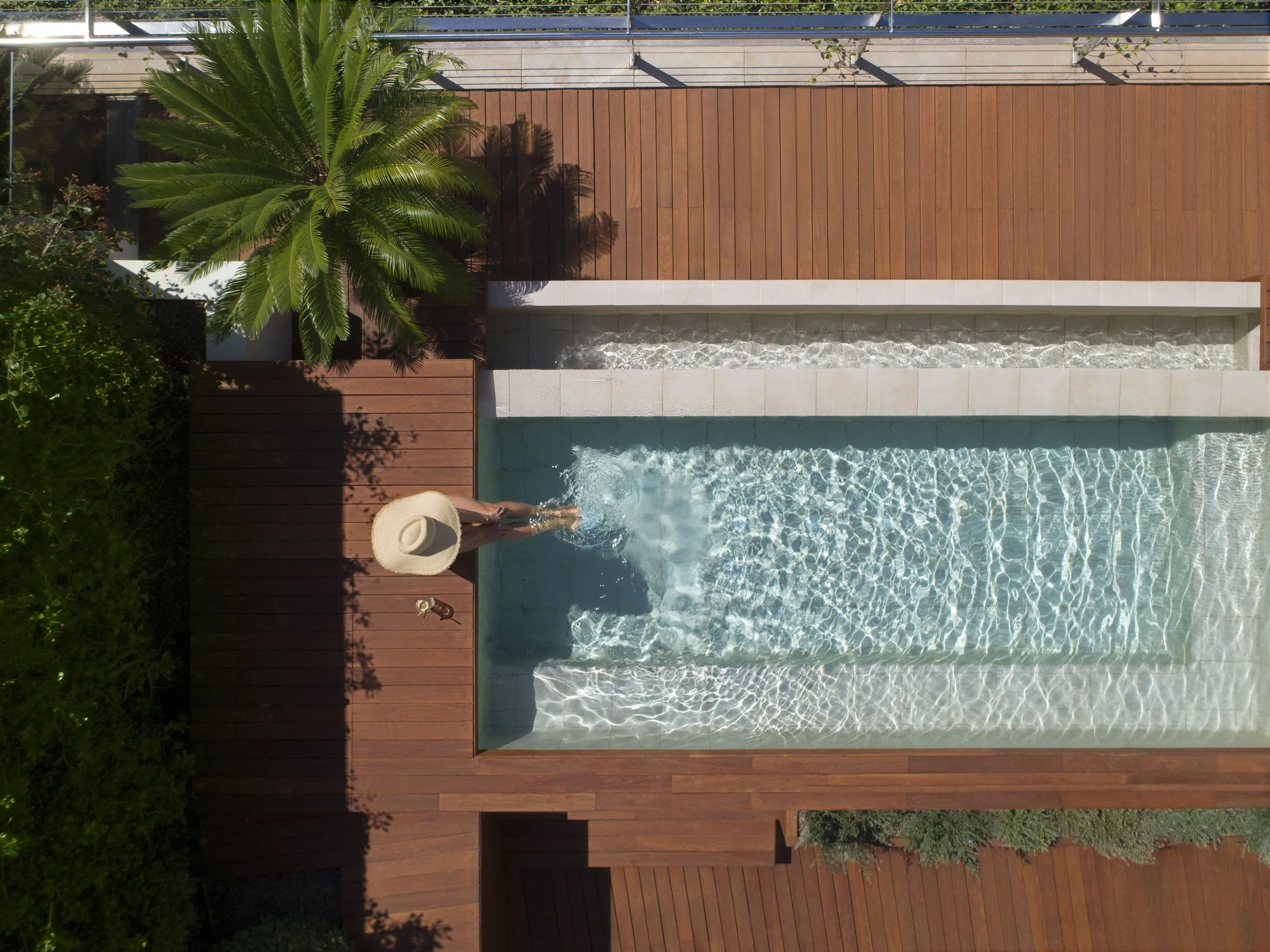 Ariel view of hotel pool with lady in a hat poolside