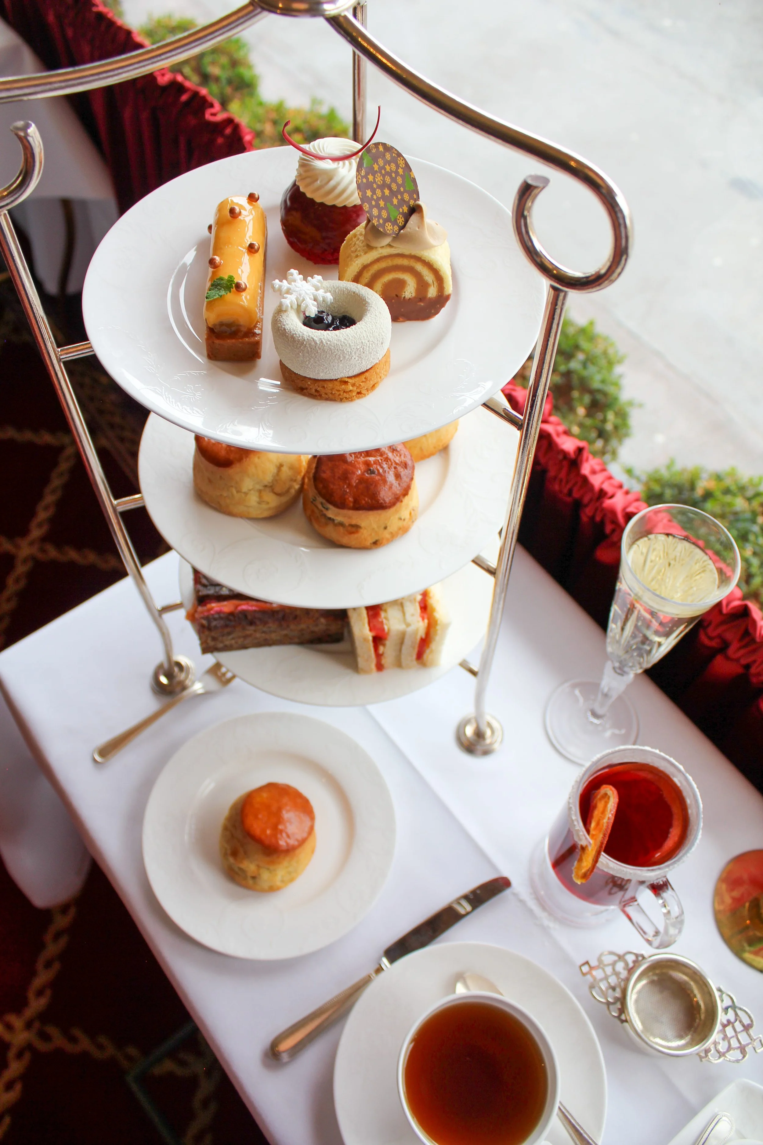 An aerial shot of an lake stand with four Christmas themed cakes on the top and sandwiches and scones underneath
