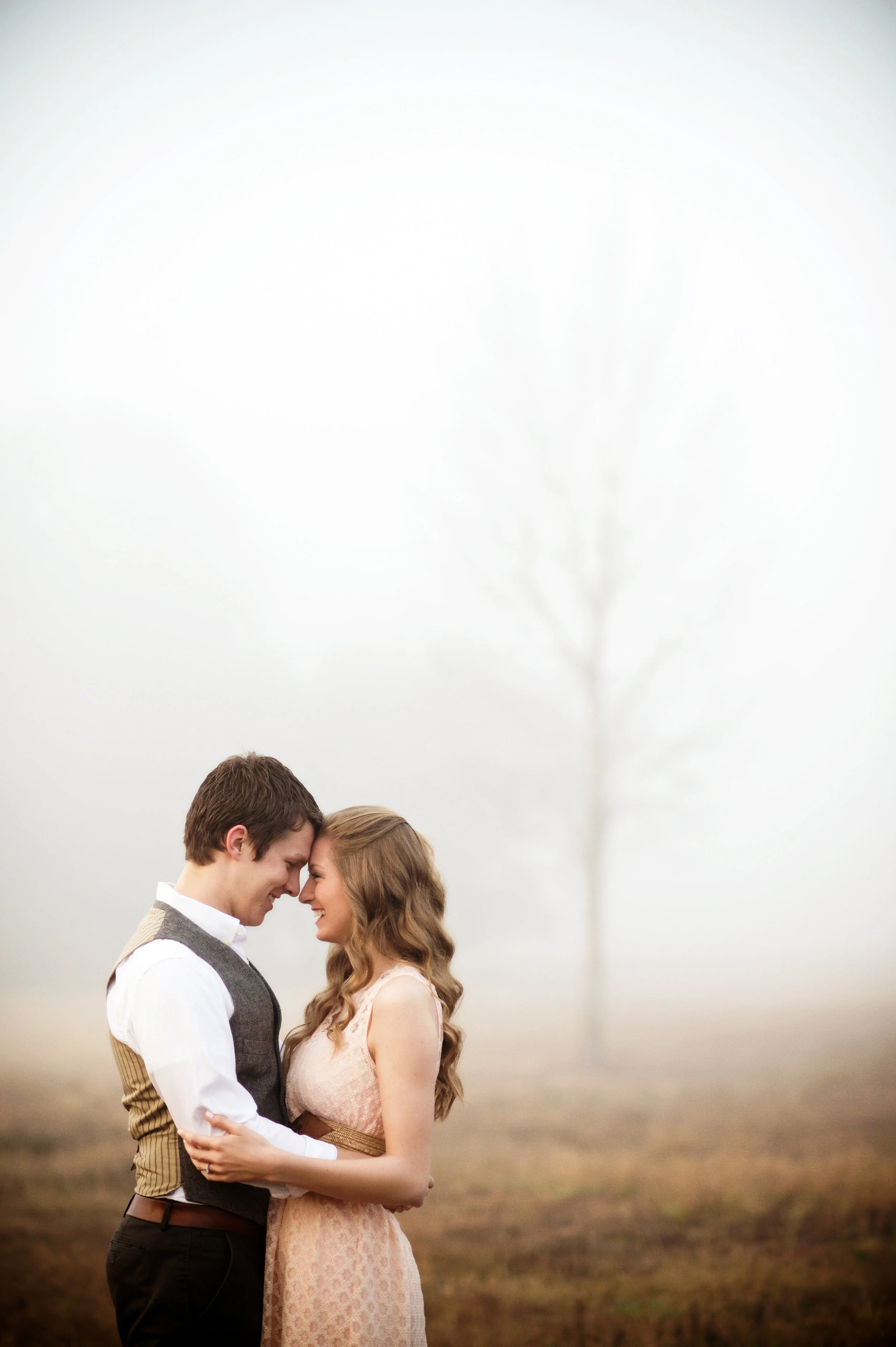 Outdoor Engagement Photography in a field at Sunrise with trees