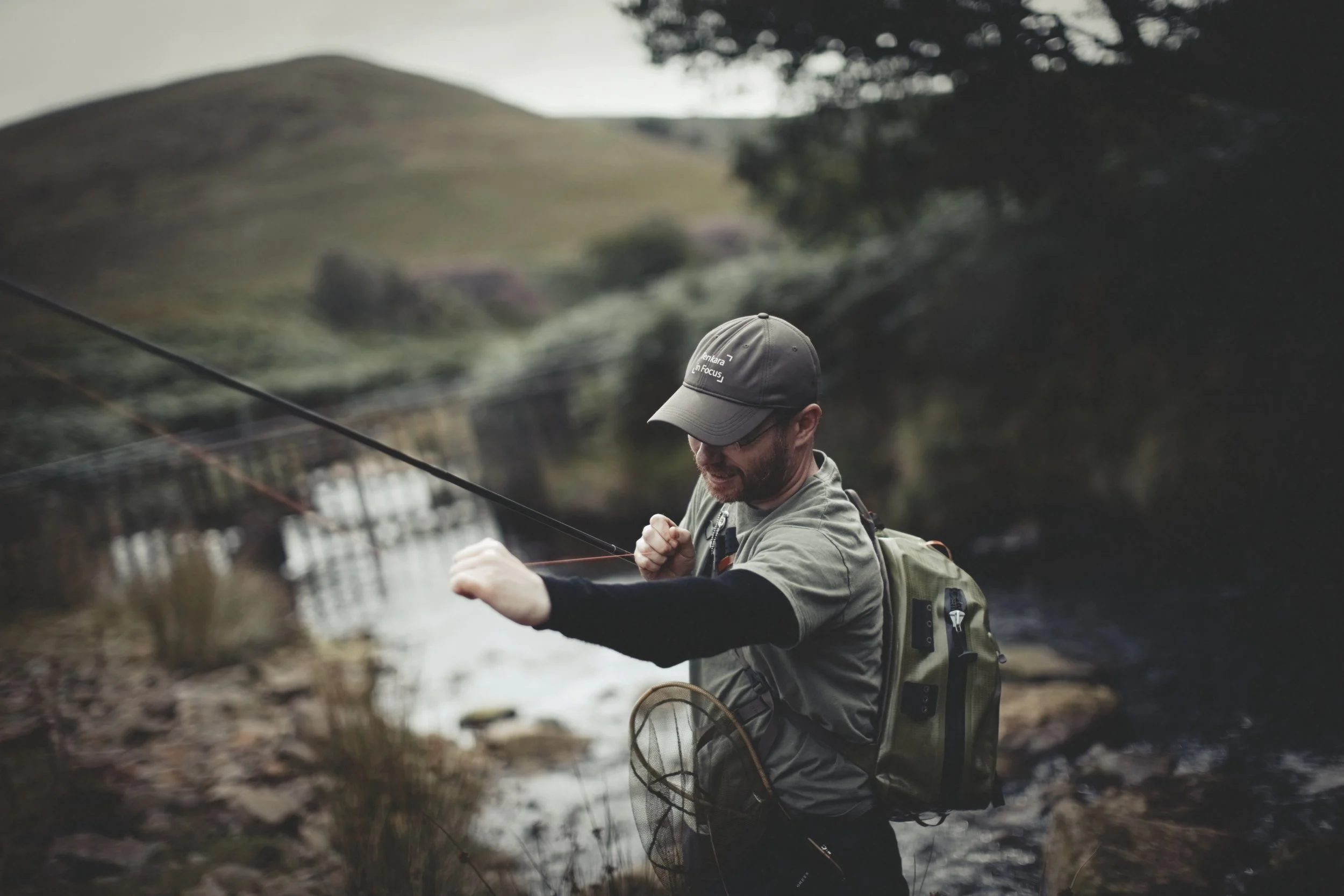 Making final adjustments to the fly line, stream in background 