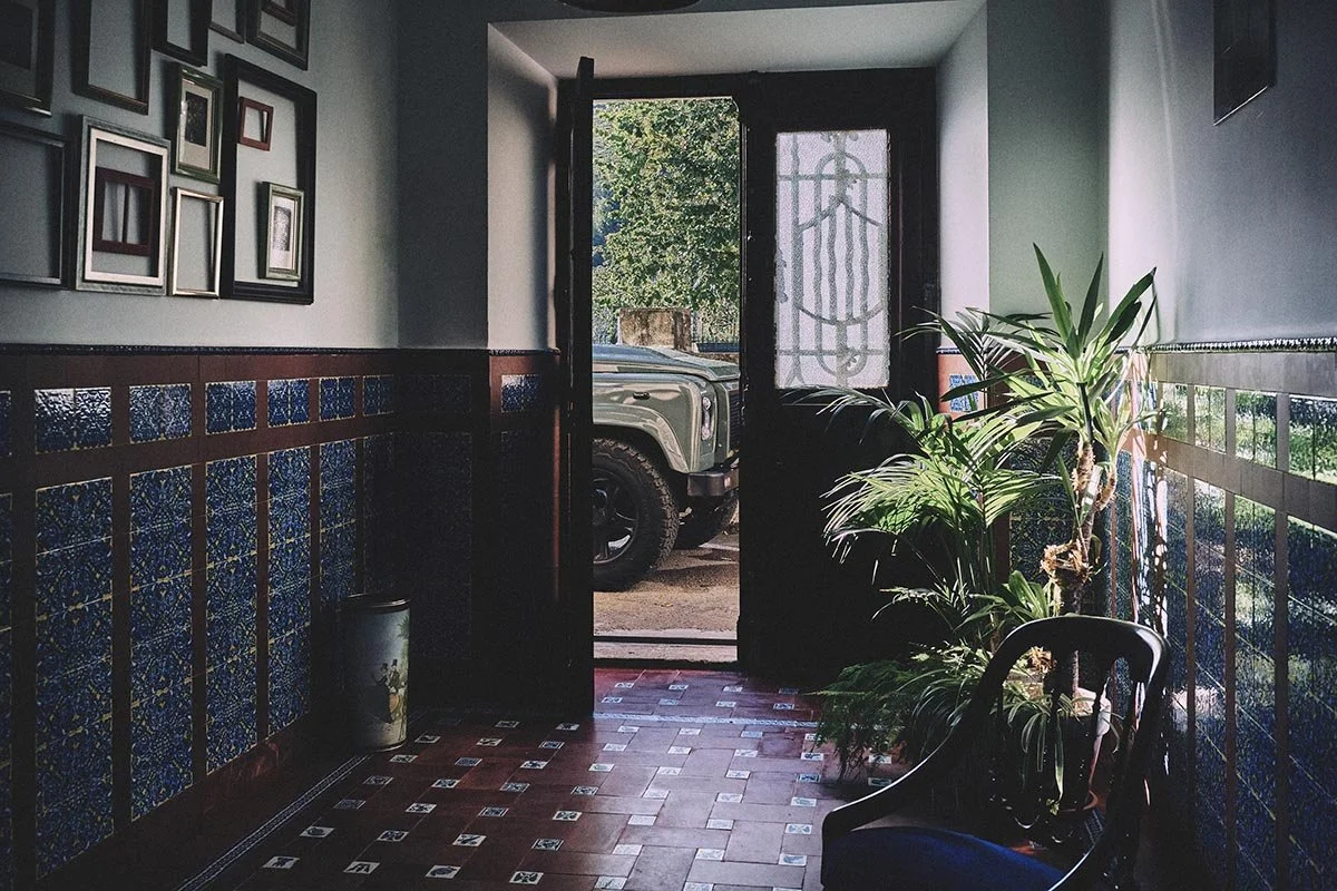 the front of a Land Rover visible through the slightly ajar door of a Spanish house by photographer Matthew Lloyd