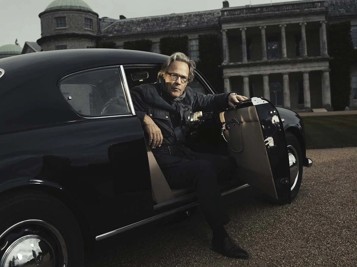 Lord Goodwood of Sothebys poses in his classic car, in this editorial portrait by Matthew Lloyd