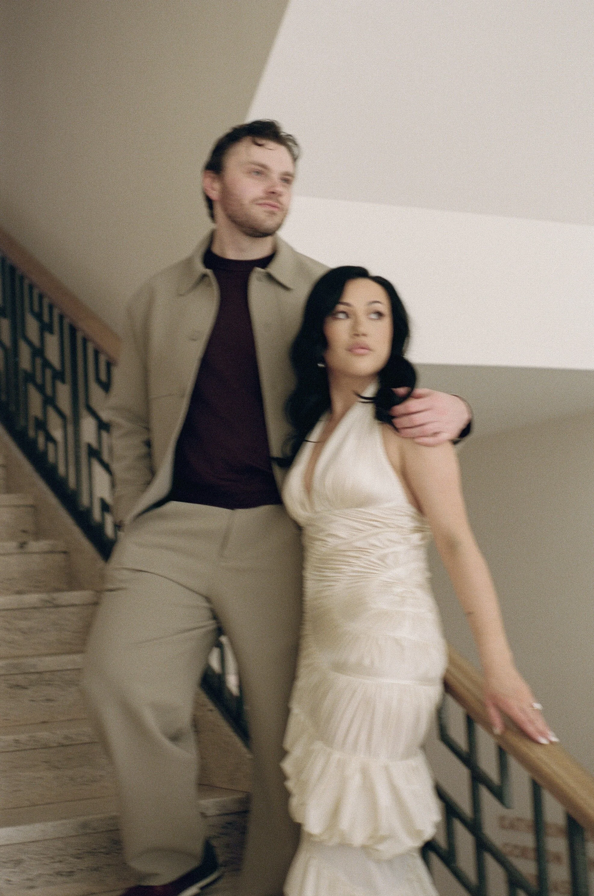  Rachel and Dakota standing closely in the Portland Art Museum with minimalist architecture behind them, artistic engagement photos in Portland, shot on film 
