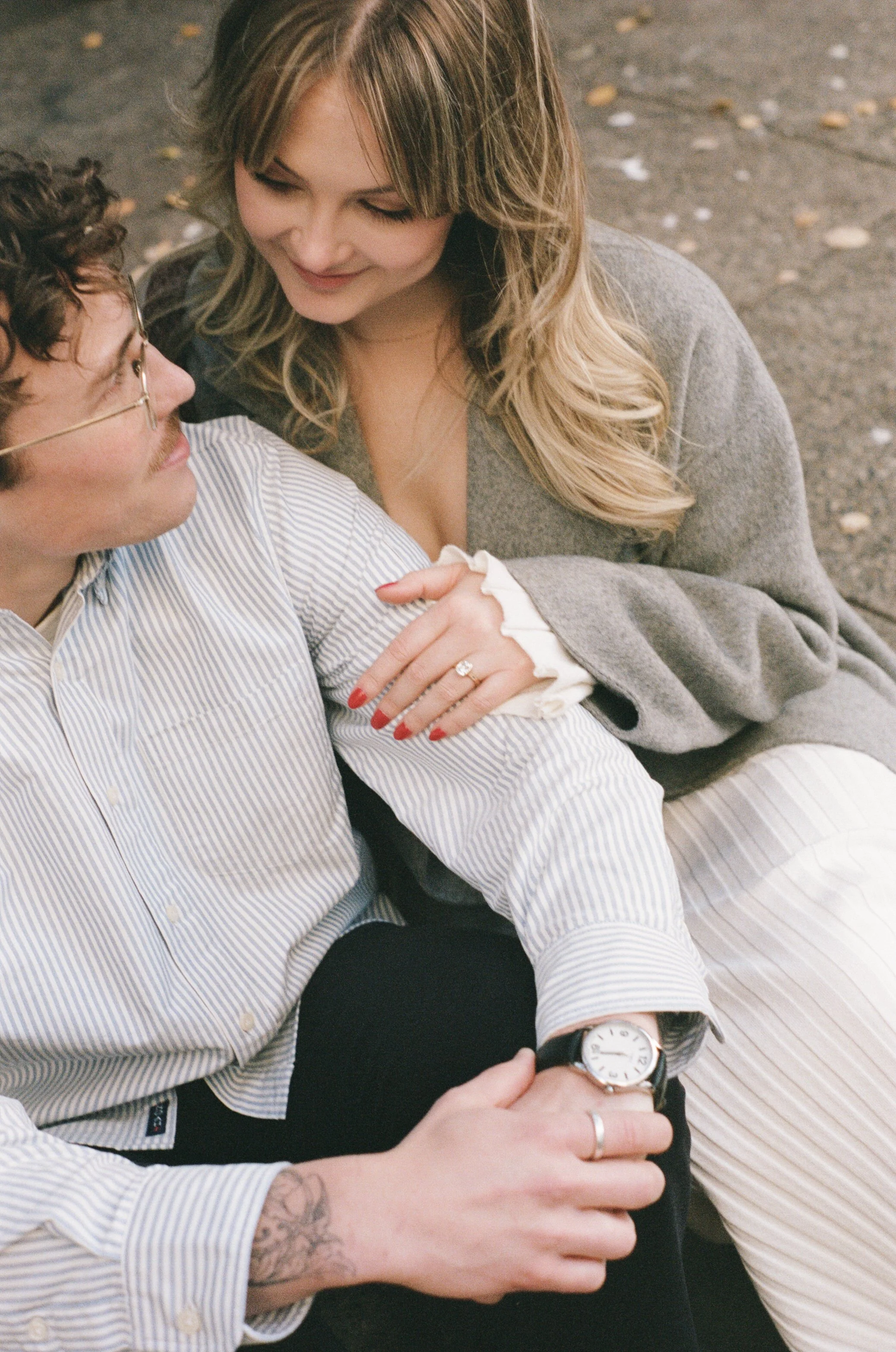  couple walking through downtown Portland in autumn with golden leaves and modern architecture, candid engagement photography 