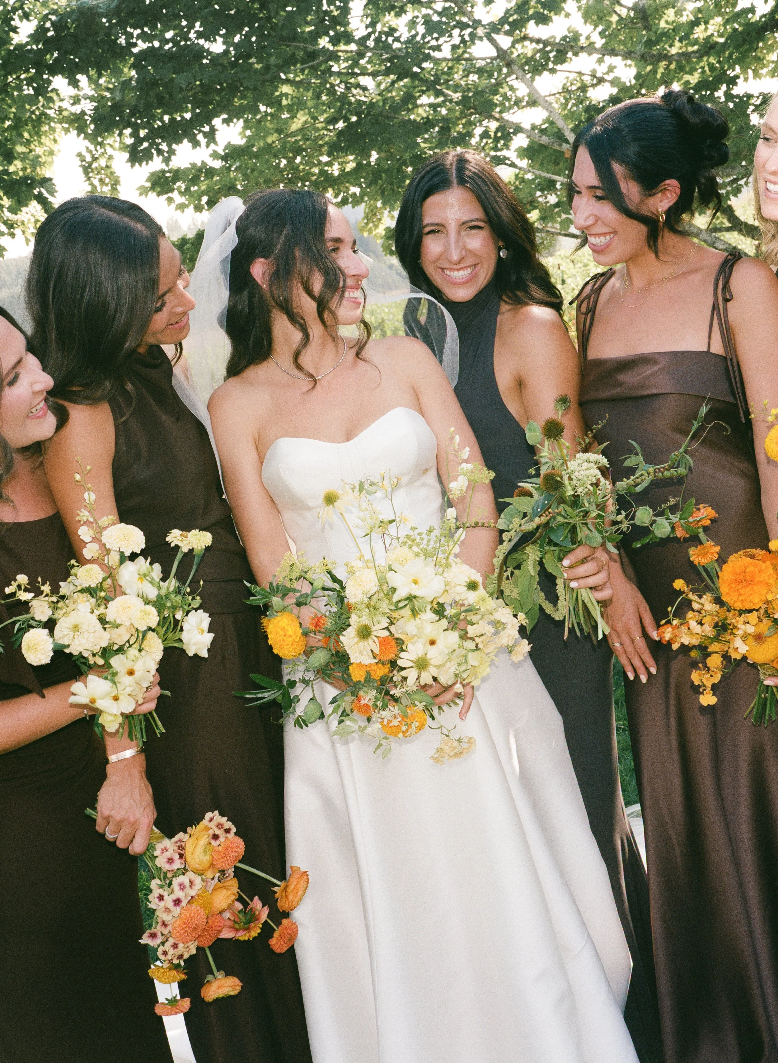  Film photograph of vibrant wedding florals with marigolds and greenery by Brier and Ivy and chocolate brown bridesmaid dresses 